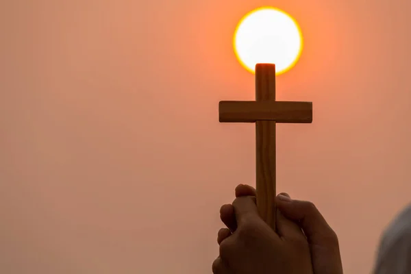 若い女性たちの手は十字架を持って神に祈りました 太陽が高い宗教的概念を設定している間 信仰の十字架 神への信仰 戦いと神の勝利 — ストック写真