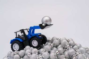 Gümüş mücevher yığını üzerinde mavi traktör. Kış tatili atık sorunu kavramı
