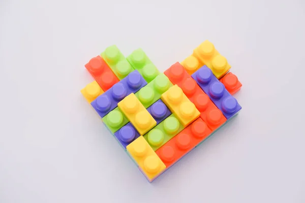 Gri arkaplanda çok renkli lego bloklarından yapılmış kalp