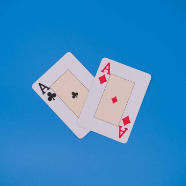 Mavi arkaplanda sinek asları ve elmasları gösteren iki oyun kartı