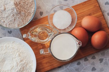 Özel biri için yemek pişirmek. Ev yapımı krep için malzemeler. Üst görünüm, seçici odak