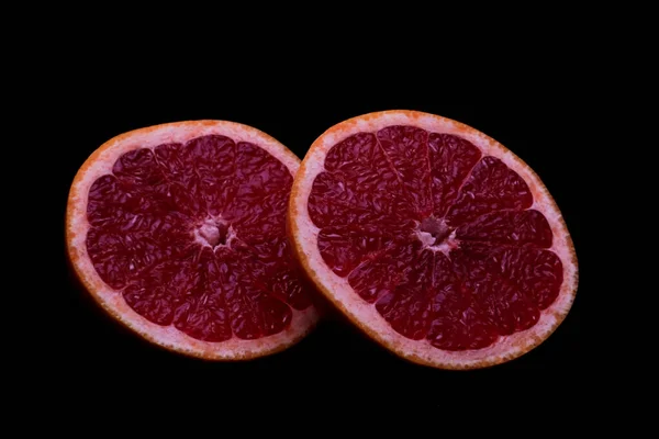暗い背景に新鮮なグレープフルーツの2つの部分 — ストック写真