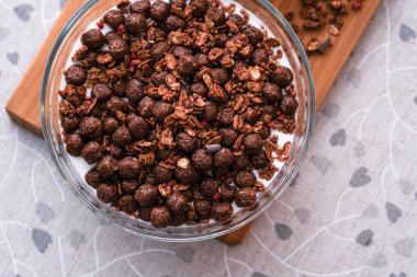 Doğal yoğurt, mısır gevreği ve cam kasede tahıl gevreği ile sağlıklı bir kahvaltı. Clouseup, üst görünüm