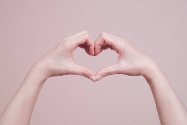 Kalp şeklinde bir kadın eli. El işaretleri iletişim konsepti