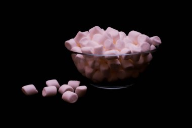 Koyu arkaplanda cam kasede şekerleme. Yaklaş, boşluğu kopyala