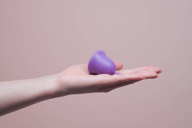 Adet bardağı açık kadın elinde, yakın plan. Kadın hijyeni ve sağlık konsepti