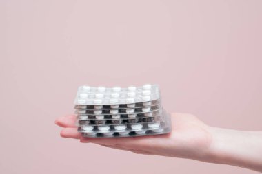 Kadın elinin üzerine ilaç yığını, yakın plan. Kopya alanı olan eczane ve tıp konsepti