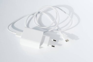 Beyaz arka planda kablo fişi usb şarj cihazı, üst görünüm. Minimalist teknoloji kavramı