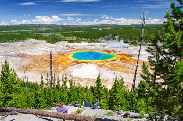 Un excursionista mirando hacia abajo en la Gran Primavera Prismática del Parque Nacional Yellowstone en el Parque Nacional Yellowstone, la fuente termal más grande de los Estados Unidos, y la tercera más grande del mundo . — Foto de Stock