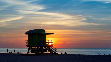 Güneşin doğuşu ve can kurtaran kulesi, Güney Miami Plajı, Florida.