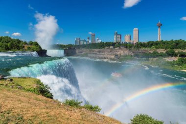Niagara Şelalesi manzarası ve muhteşem gökkuşağı. American Falls, Horseshoe Falls ve arka planda Kanada gökdelenleri.