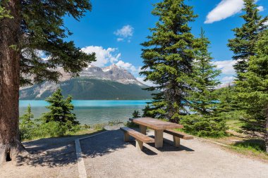 Kanada Banff Ulusal Parkı 'nda güzel bir göl kenarında piknik alanı, masa ve banklar..   