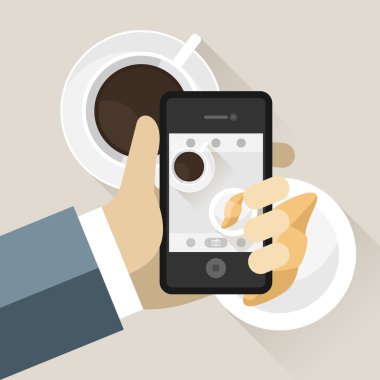 Smartphone alarak fotoğraf kruvasan ve kahve fincanı