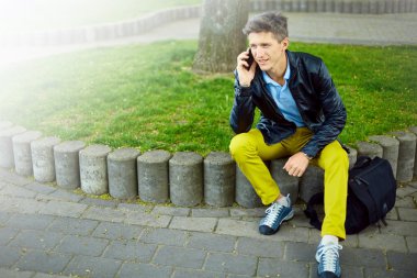 Akıllı telefonu olan genç bir adam.