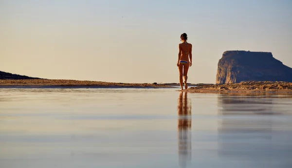 Nainen juoksee rannalla — kuvapankkivalokuva
