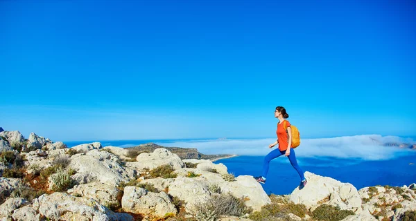 Kvinne som løper på klippen – stockfoto