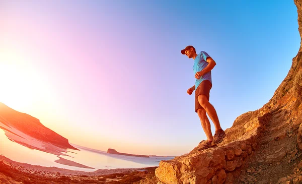 Чоловічий пішохід, мандрівник біжить по стежці проти моря і блакитного неба — стокове фото