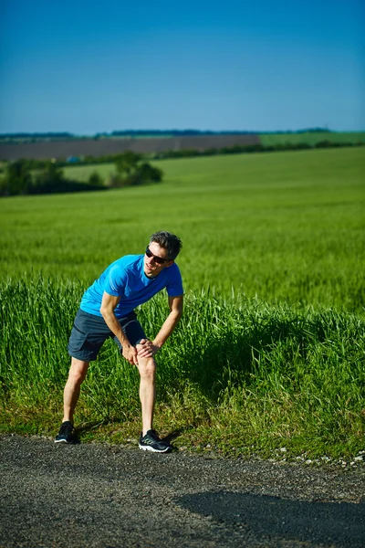 Мужчина бегун разогревается перед пробежкой — стоковое фото
