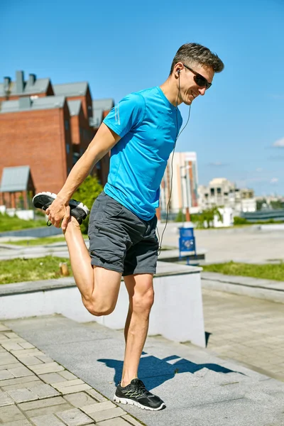Мужчина бегун разогревается перед пробежкой — стоковое фото