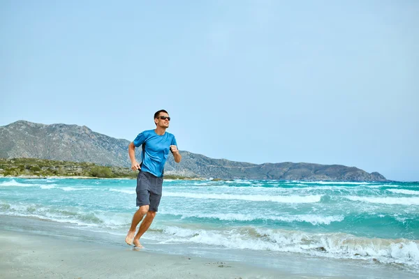 Мужчина бежит по пляжу — стоковое фото