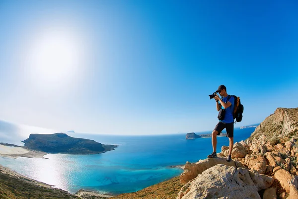 Valokuvaaja kalliolla meren taustalla — kuvapankkivalokuva