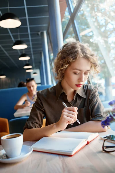 Woman with notebook in cafe — Stock Photo, Image