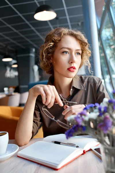 Kvinne med notatbok på kafe – stockfoto