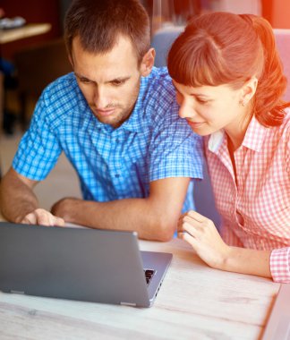 Genç adam ve kadın dizüstü bilgisayar ile