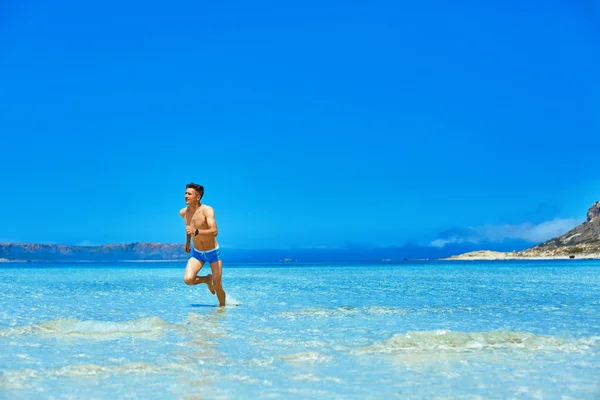 Mann läuft am Strand — Stockfoto