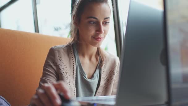 Mujer sonriente joven usando ordenador portátil portátil. — Vídeos de Stock