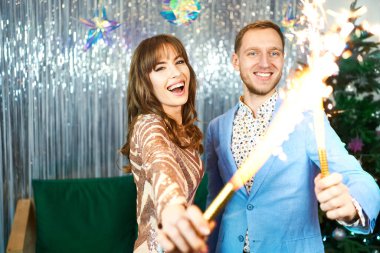 Mutlu duyguların parlak ifadeleri, çift gülüyor ve havai fişeklerle birlikte kutluyor.