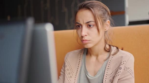 Zamyślona kobieta pracująca pilnie na laptopie — Wideo stockowe