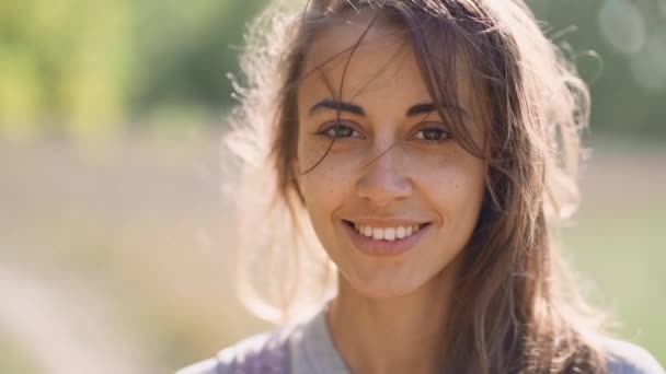 Calm destul de zâmbitoare femeie în aer liber cu suflare de păr la soare toamna zi — Videoclip de stoc