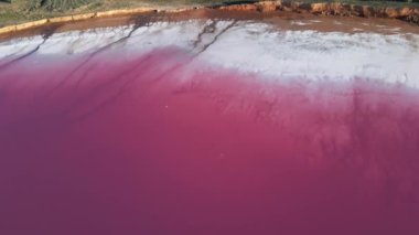 Geniş beyaz tuz sahili ve pembe suyla inanılmaz renkli göl manzarası