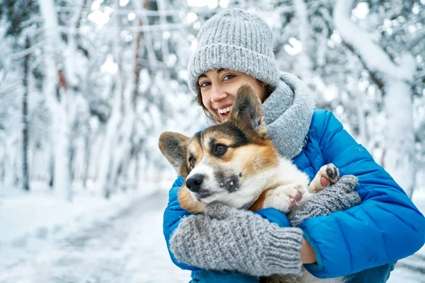 สาวที่แต่งตัวดีและสุนัข Corgi กลางแจ้งในฤดูหนาว — ภาพถ่ายสต็อก