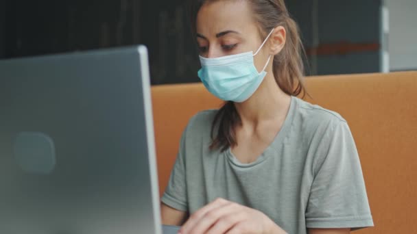 Gemengd ras vrouw medisch masker kijkt recht op camera — Stockvideo