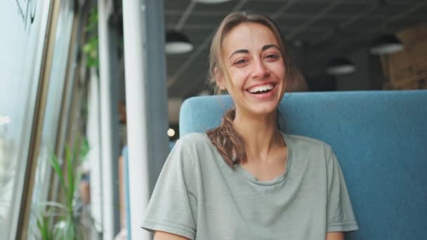Lykkelig kvinde sidder og griner af sjov joke – Stock-video