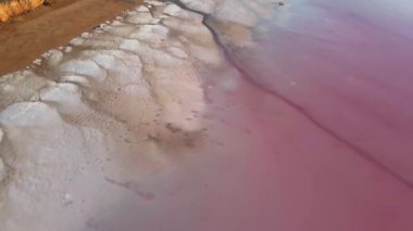 Pembe gölün kırmızı kil kıyısında tuz birikintileriyle İHA uçuşu