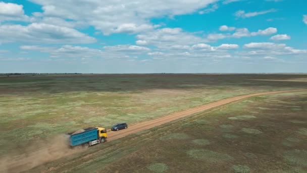 Luchtfoto auto en vrachtwagen bewegen door rustieke weg door groene velden — Stockvideo