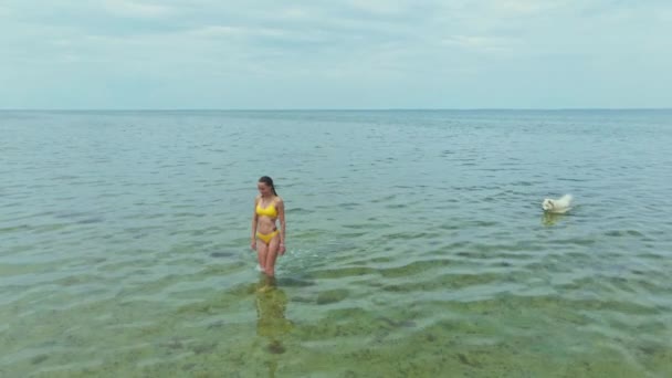 Câmera lenta drone mulher em biquíni amarelo indo para o mar — Vídeo de Stock