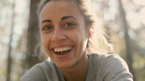 Крупним планом щаслива молода жінка сміється і похмуро в лісі — стокове відео