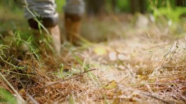 Erkeklerin yürüyüş botlarını kapatır, ormanda çimenlerde yürürler.