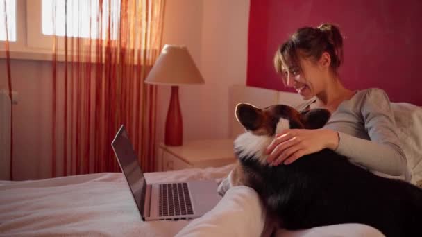 快乐的女人躺在床上和男朋友聊天，用笔记本电脑打视频电话，用无线速度上网. — 图库视频影像