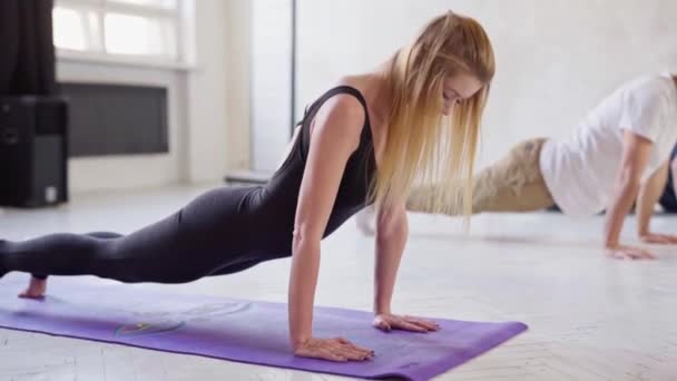 Frau praktiziert Yoga, steht in abwärts gerichteter Hundepose — Stockvideo