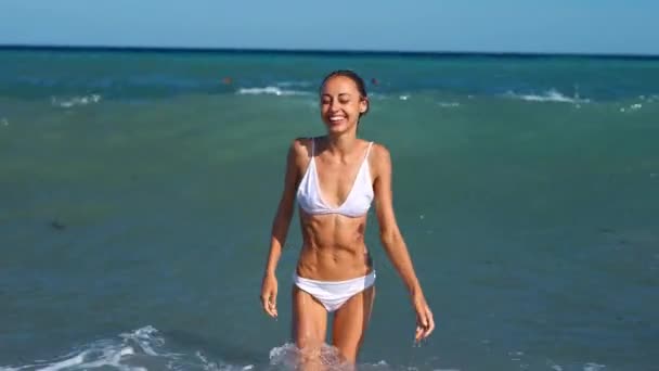 웃는 즐거운 날씬 한 여자가 바다에서 나온다 — 비디오