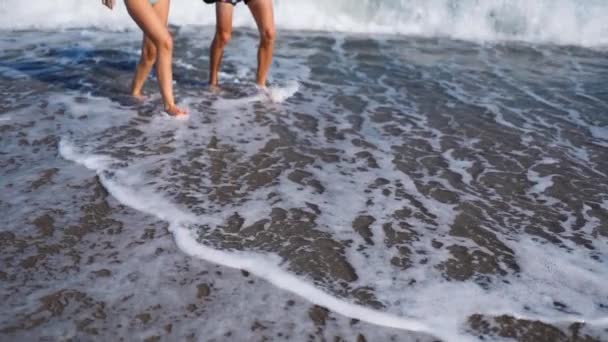 Câmera lenta casal pernas e ondas na praia do mar de seixos. — Vídeo de Stock