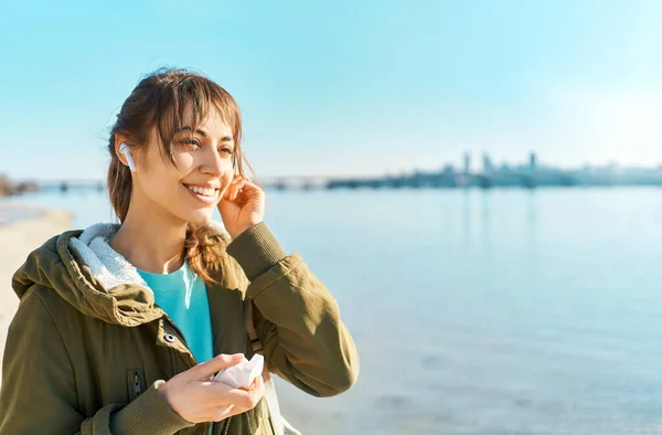 Lifestyle outdoors potrait girl walking and listening music in wireless earphones — Stock Photo, Image
