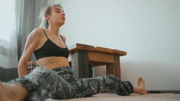 Jovem atlético muscular mulher magra alongamento pernas em casa — Vídeo de Stock