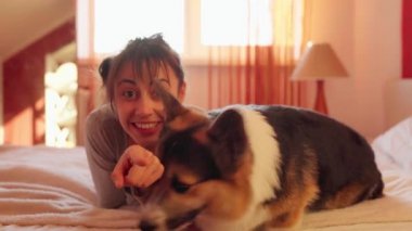 Kız kameranın yanında köpeğe ilginç bir şey gösteriyor.