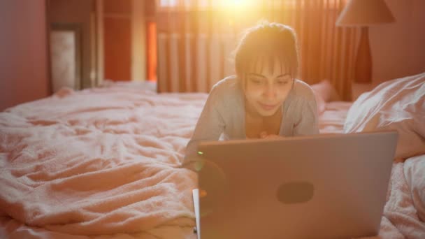 Mulher freelancer ou estudante deitado cama usando laptop durante a quarentena — Vídeo de Stock